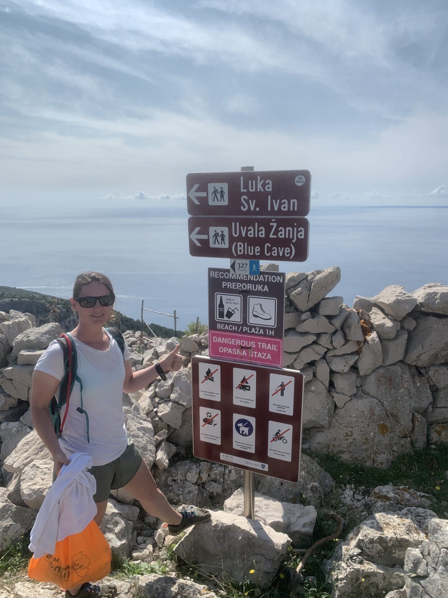 Sara posing in front of the sign to make sure to take plenty of water with you.