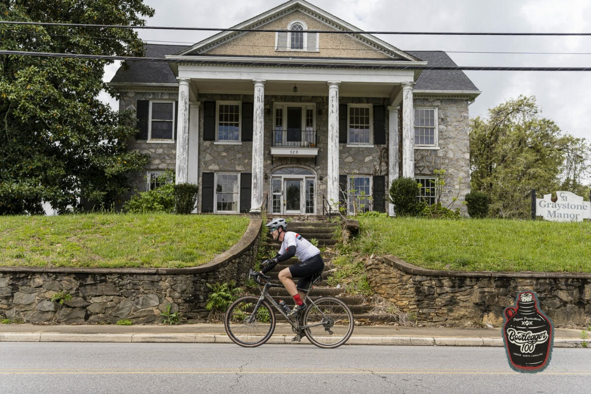 person riding past a house near the start of the race