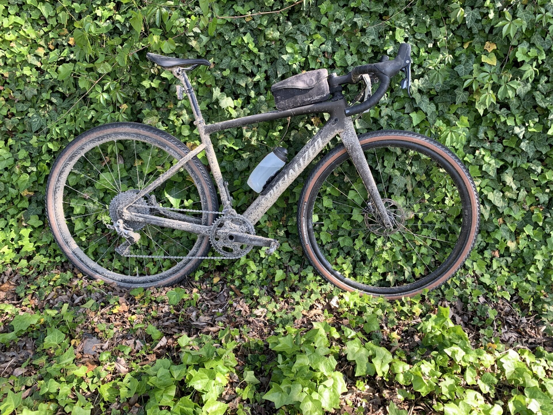 Fidlock bottle on dirty gravel bike with ivy covered wall in background